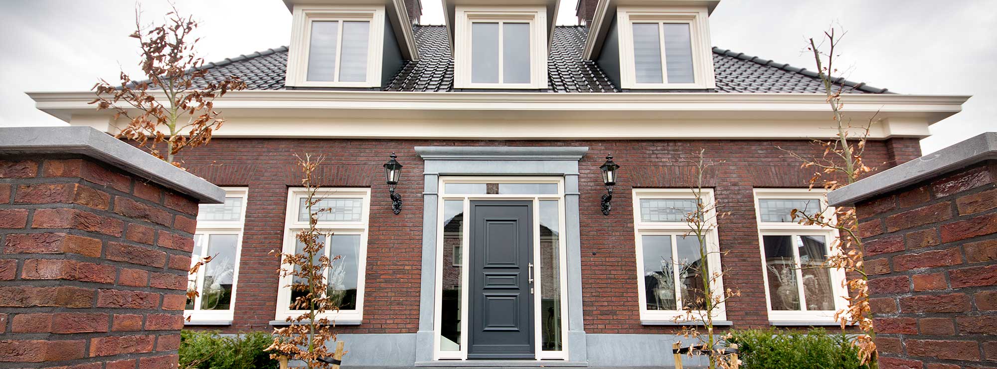 Stijlvolle grijze kunststof voordeur met zijlichten in typisch Hollandse stijl.
