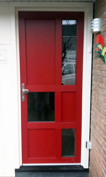 Kunststof voordeur in opvallend rood, met wit kozijn.