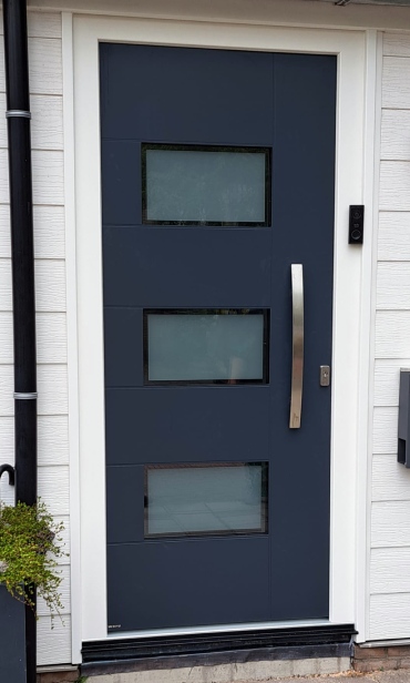 Kunststof buitendeur met aluminium deurpaneel en drie matglas ramen. 