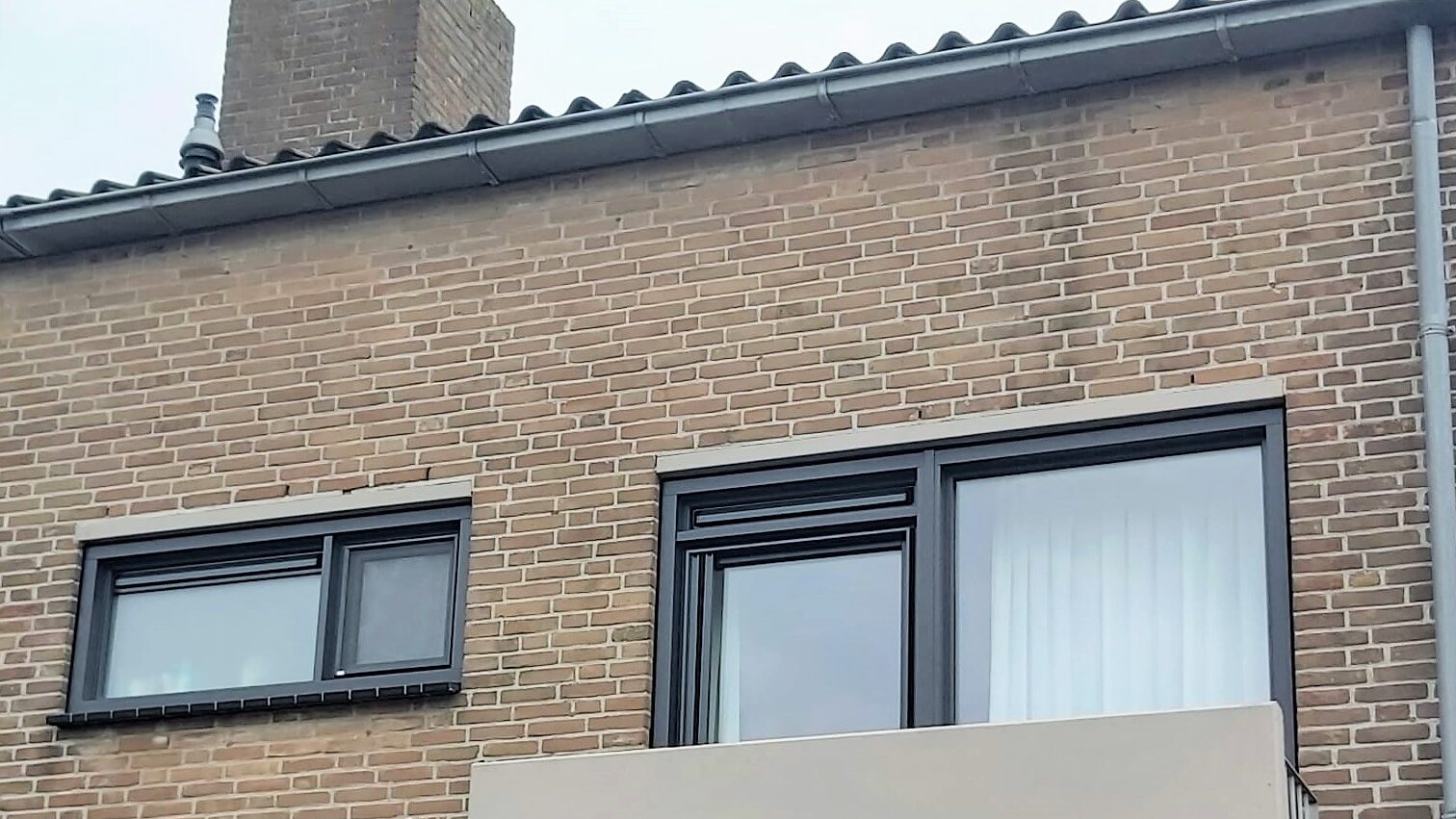 Kunststof balkondeur en kunststof kozijnen Weru Castello Trado in antraciet met houtlook en rechte lasverbinding. Inclusief bijpassende ventilatieroosters, hordeur en inzethor. Geïnstalleerd in Katwijk.