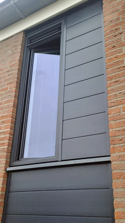 Gevelbekleding vervangen: Mondana aluminium kozijnen in zwartgrijs (RAL 7021). Keralit rabat en ventilatierooster in dezelfde kleur. Eindresultaat.